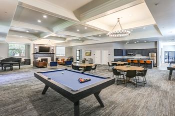 a large gathering room with a pool table and several tables and chairs